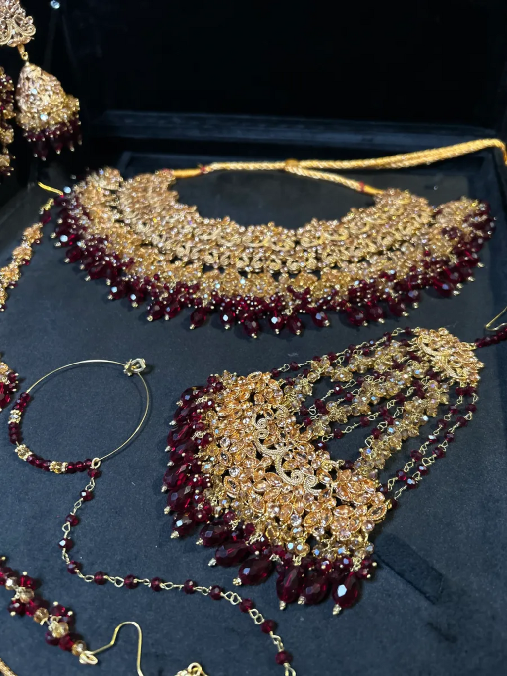 Luxury Maroon Crystals & Gold set, with heavily beaded earrings & tikka. - Jewelsbyrani